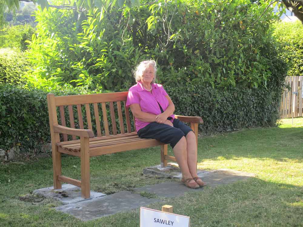 councillor sitting on new bench in sawley